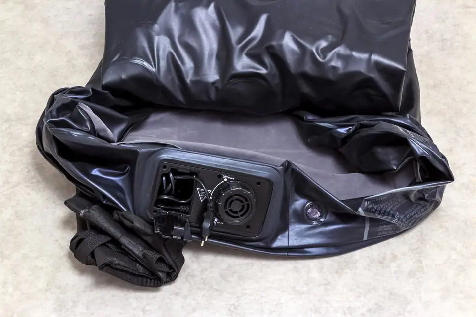 Deflated air mattress showing its built-in electric pump panel and power cord
