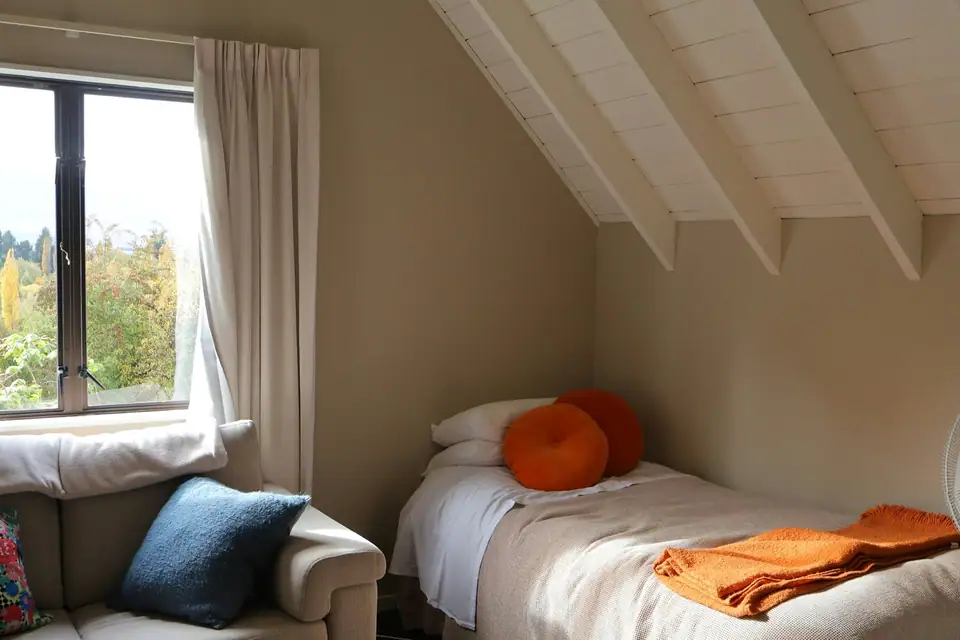 Small guest room with a single bed under a window