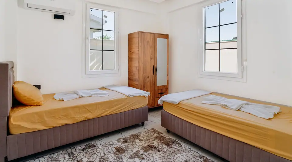 Two twin beds side by side in a bright bedroom