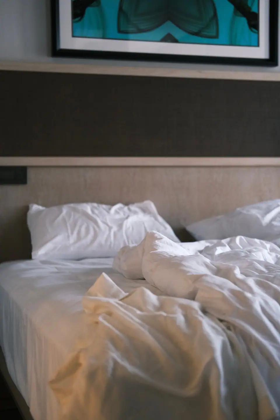 White fitted sheet, duvet and pillows on a freshly used bed